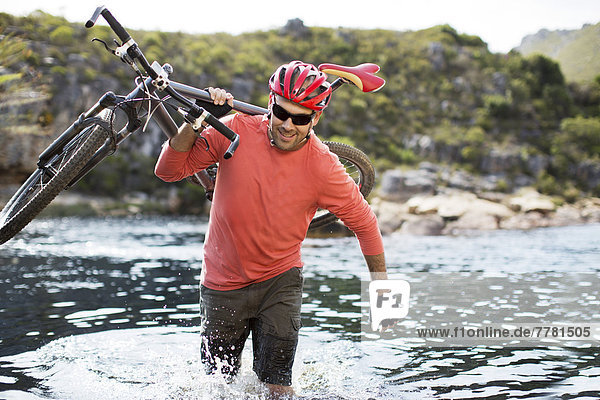 Mann mit Mountainbike im Fluss