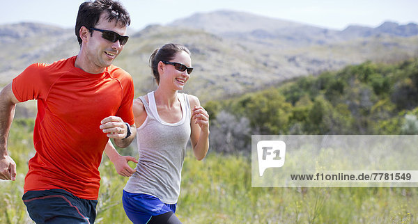 Couple running in rural landscape