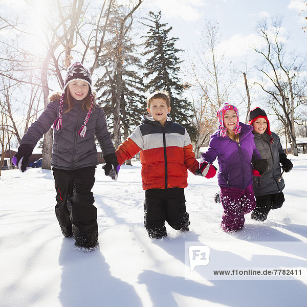 Caucasian children walking in snow outdoors