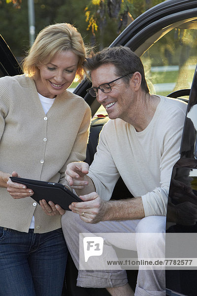 Caucasian couple using digital tablet in car