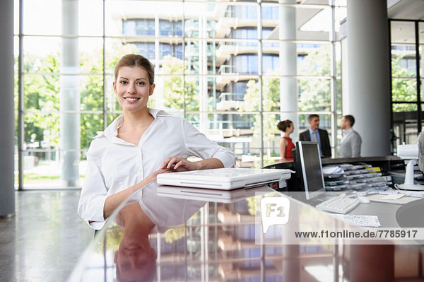 Business woman leaning against reception desk
