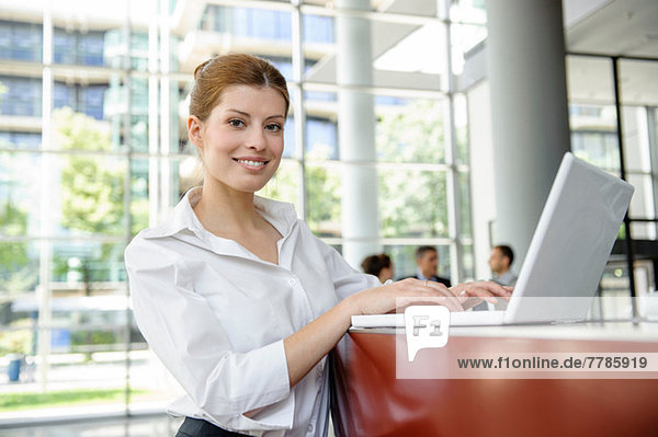 Business woman using laptop on reception desk