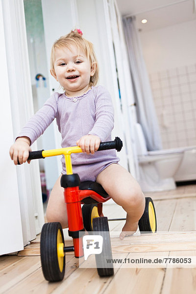 Kleinkind Mädchen spielt auf Dreirad