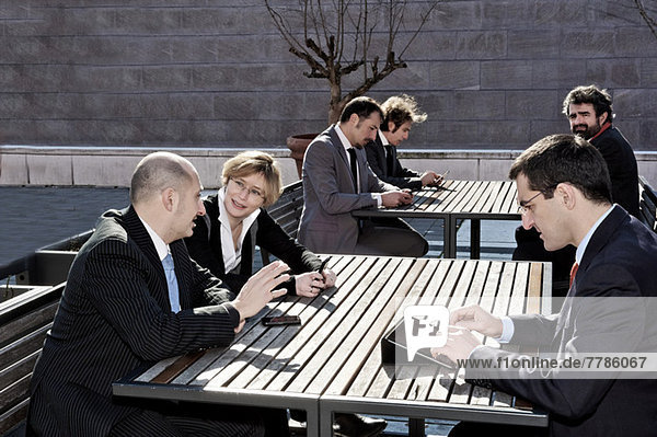 Business people working at outdoor tables