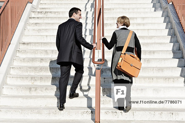 Geschäftsfrau und Mann aufsteigende Treppe  im Freien