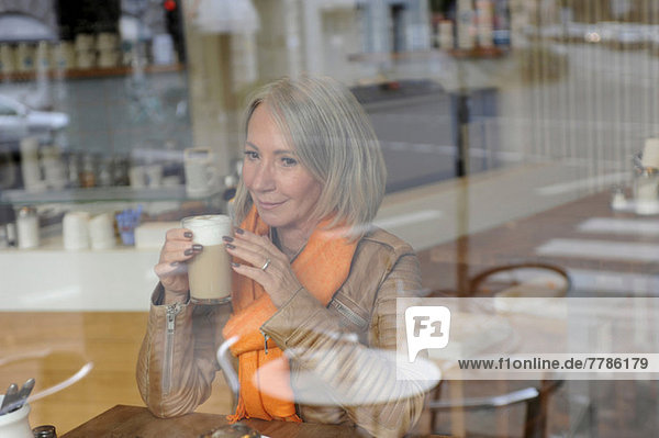 Seniorin auf dem Coffee Shop sitzend