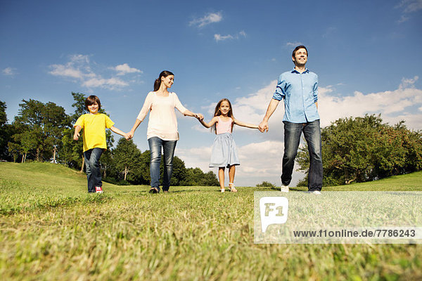 Family with two children holding hands  walking