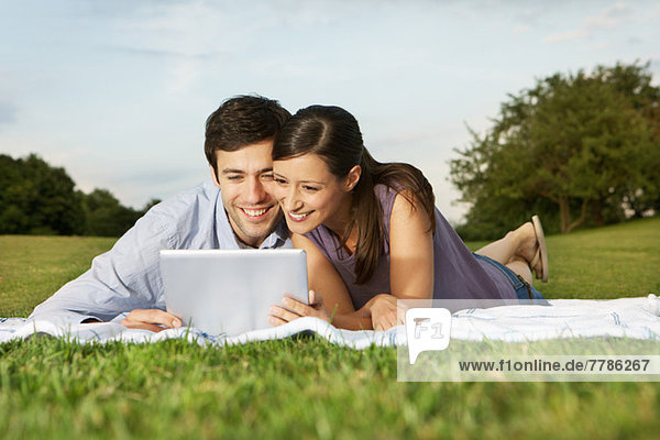 Mid adult couple using digital tablet
