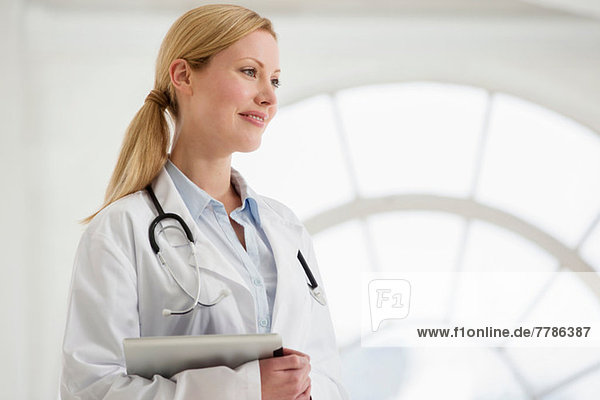 Porträt einer Ärztin mit Stethoskop und digitalem Tablett