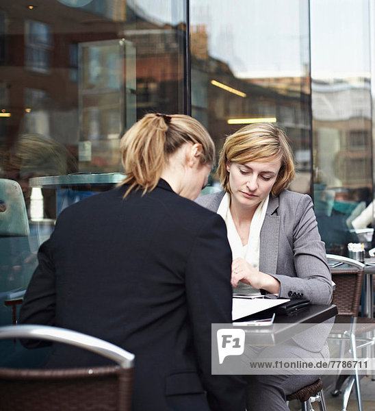 Two businesswomen meeting at outdoor cafe