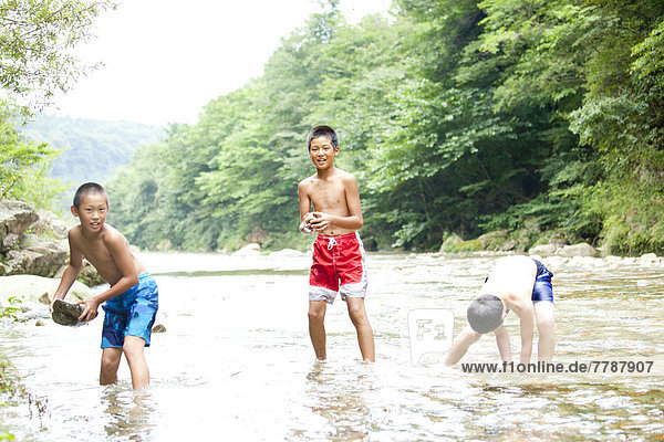 Kinder spielen in river