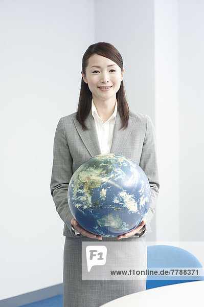 Geschäftsfrau hält einen Globus in den Händen  fully_released