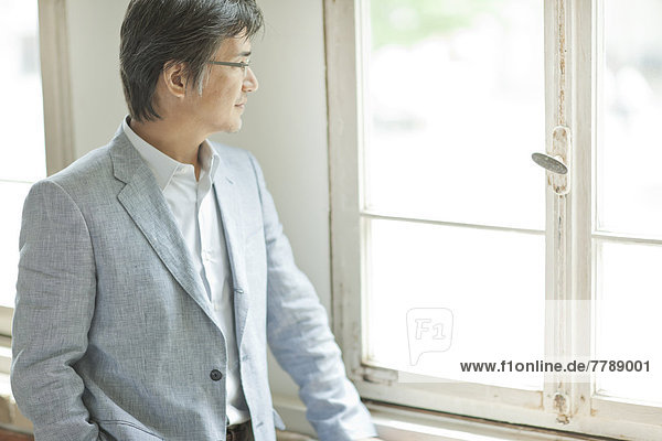 Mature man standing by the window