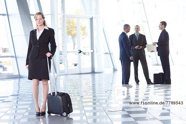 Portrait of businesswoman in airport with suitcase