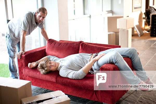Two removals men  one lying on sofa