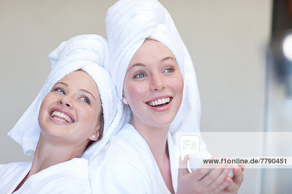 Young women wearing towels on heads with teacup