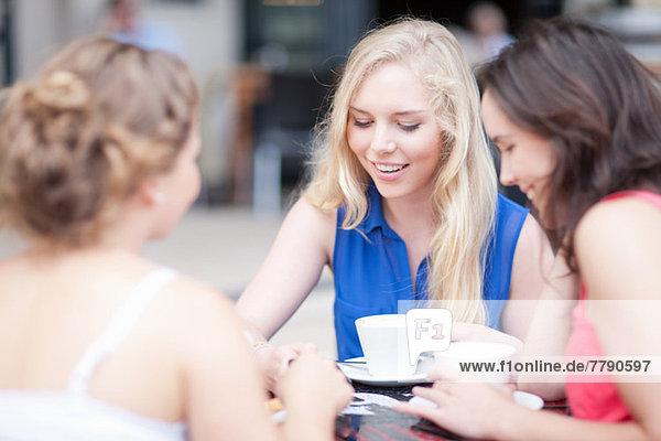 Junge Frauen beim Plaudern mit Freunden im Café