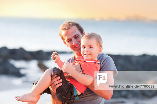 Vater spielt mit Sohn am Strand
