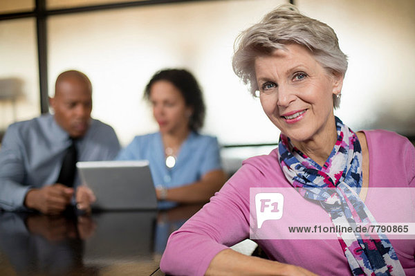 Mature woman with business colleagues in background