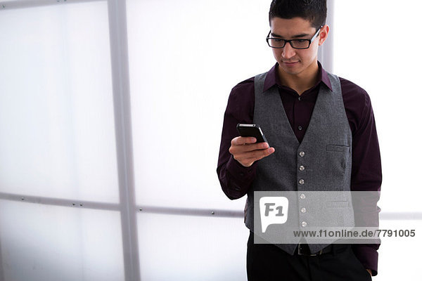 Junger Mann SMS auf dem Smartphone