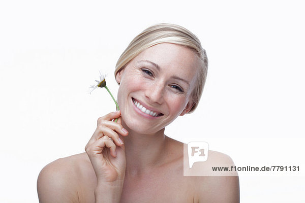 Young woman holding daisy