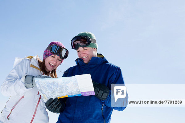 Young couple holding ski map