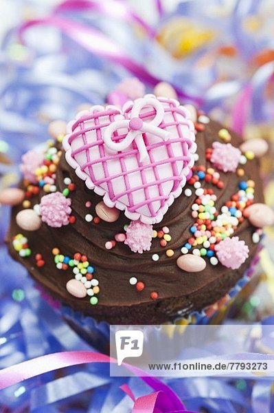 Schokoladencupcake mit pinker Herzdeko für eine Party