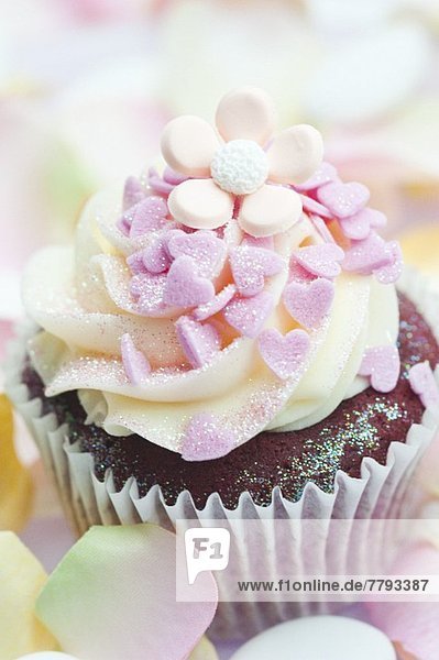Schokoladencupcake mit pinkfarbenen Zuckerherzen