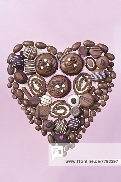 Heart made of chocolate candies  pastries and rolls