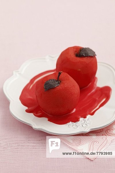 Red spiced poached apples with chocolate leaves
