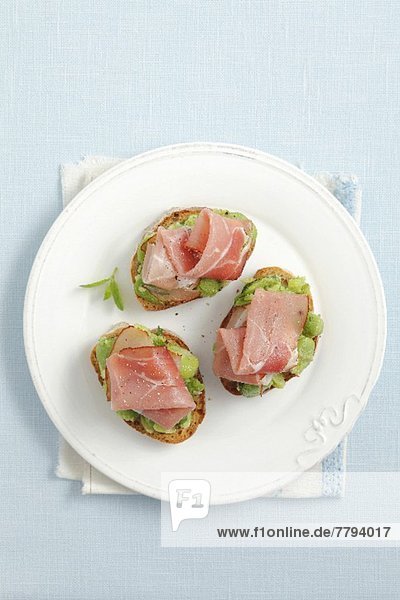 Crostini with broad beans  smoked ham and mint