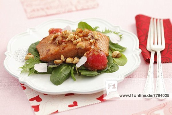 Roasted salmon fillets with shallots  cherry tomatoes  hazelnuts and petals