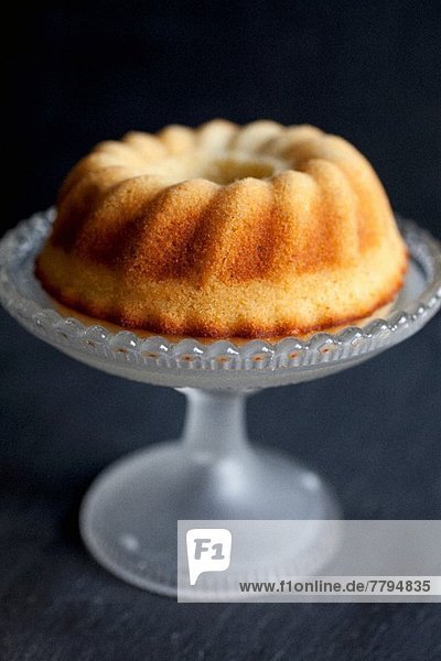 Kleiner Zitronen-Napfkuchen auf einem nostalgischen Kuchenständer