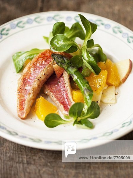 Red mullet with lamb's lettuce  asparagus and orange and apple pieces