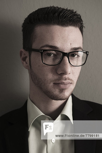 Head and Shoulder Portrait of Young Man wearing Glasses  Looking at Camera  Studio Shot
