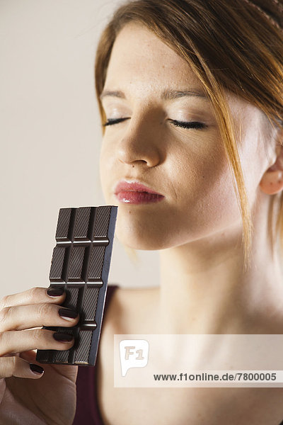 Close-up of Teenage Girl holding Chocolate with Eyes Closed  Studio Shot on White Background