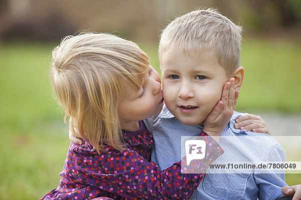 Little girl kissing a little boy