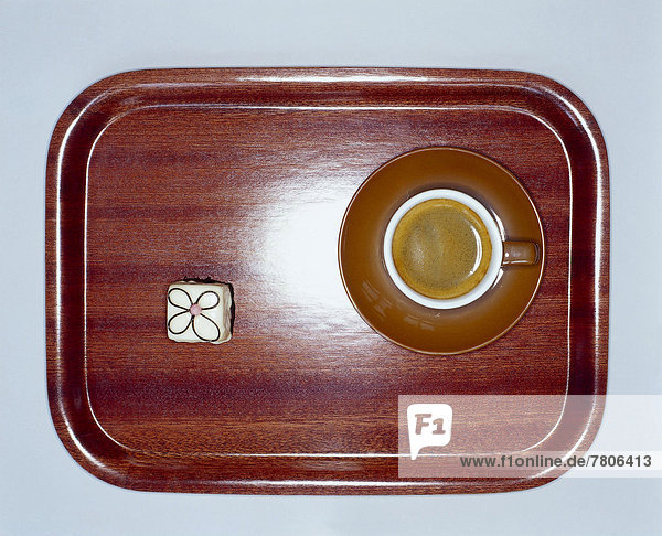 Kleines Holztablett mit Espresso und Petit Fours von oben