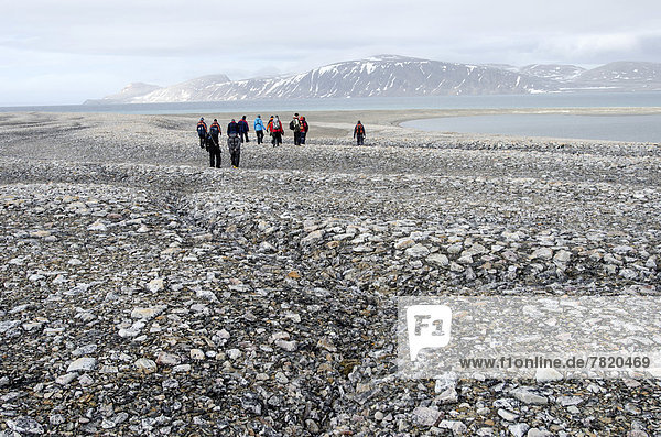 Wanderer in arktischer Eiswüste  im Vordergrund Frostrisse im Frostmusterboden