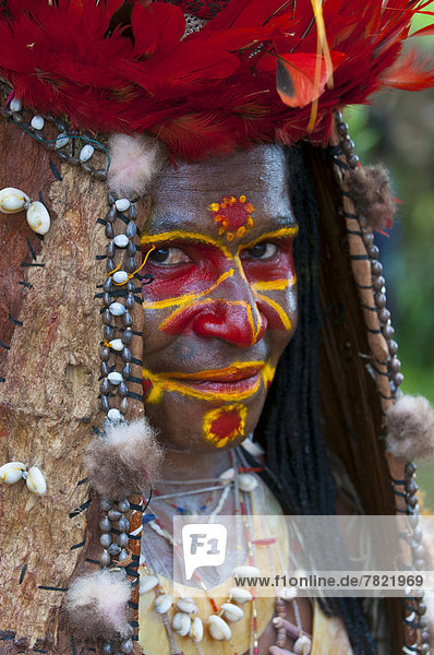 Bunt geschmücktes und bemaltes Mitglied eines Volkststammes feiert das traditionelle Sing Sing im Hochland