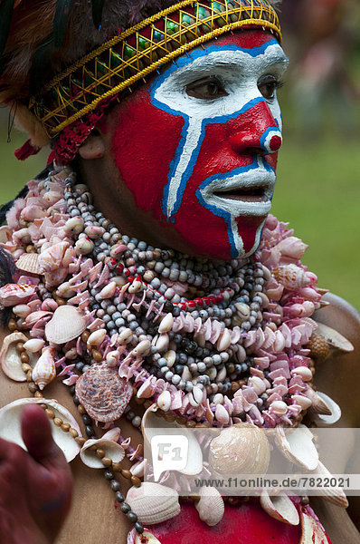 Bunt geschmückte und bemalte Frau feiert das traditionelle Sing Sing im Hochland