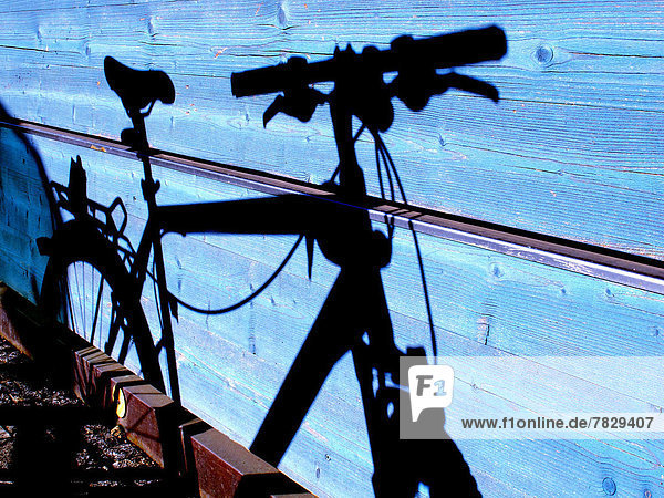 Holzwand Fahrrad Rad blau Schatten radfahren
