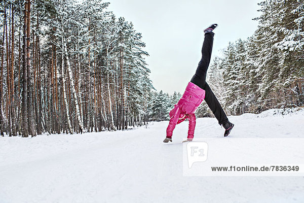 A woman doing a cartwheel in the snow