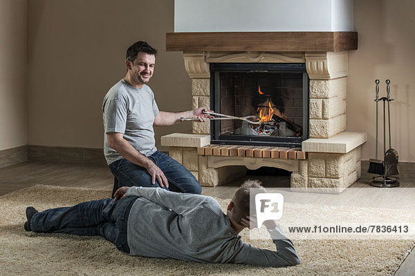 Vater und Sohn entspannen sich am Feuer