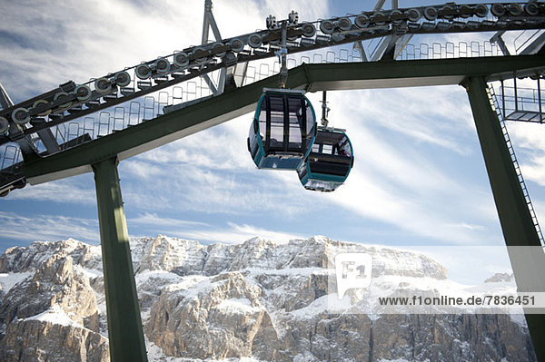 Two ski lifts with rocky mountains in the background at Selva  South Tyrol  Italy
