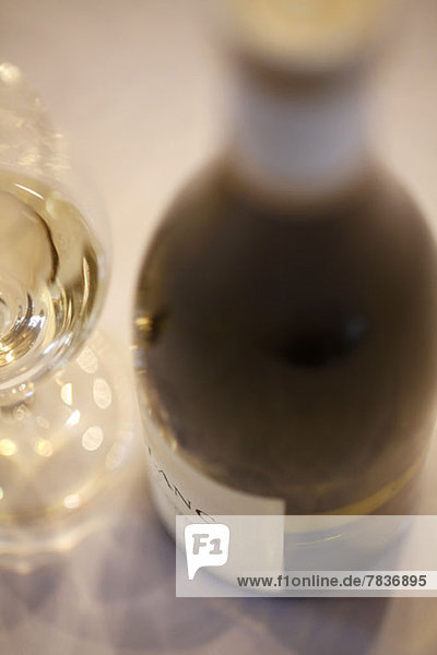 Detail einer Flasche Weißwein und eines Weinglases