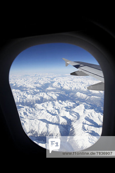 Blick vom Flugzeug auf die schneebedeckten Schweizer Alpen