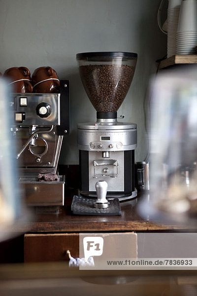 Eine Kaffeemühle neben einer Espressomaschine in einem Coffee-Shop