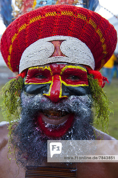 Bunt geschmückter und bemalter Stammesangehöriger feiert das traditionelle Sing Sing im Hochland