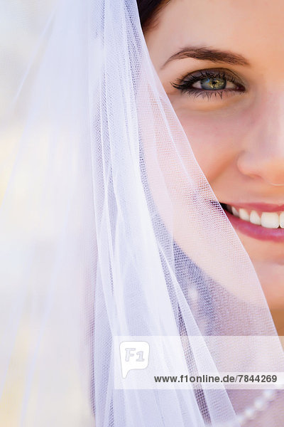 USA  Texas  Junge Braut im Brautkleid posiert am Frio River  lächelnd
